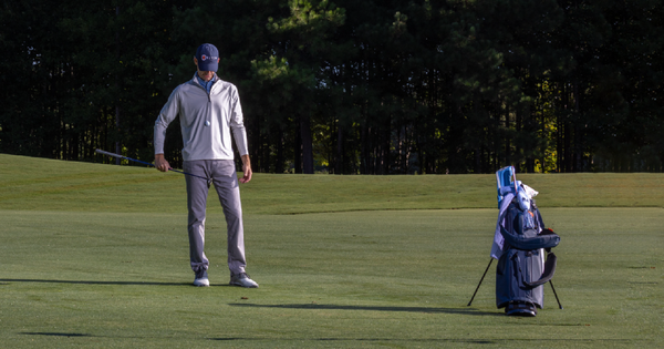 Picture of a golfer on the course contemplating whether or not he's got the right golf bag.