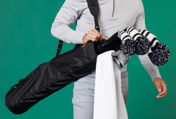 A golfer holding a Sunday golf bag